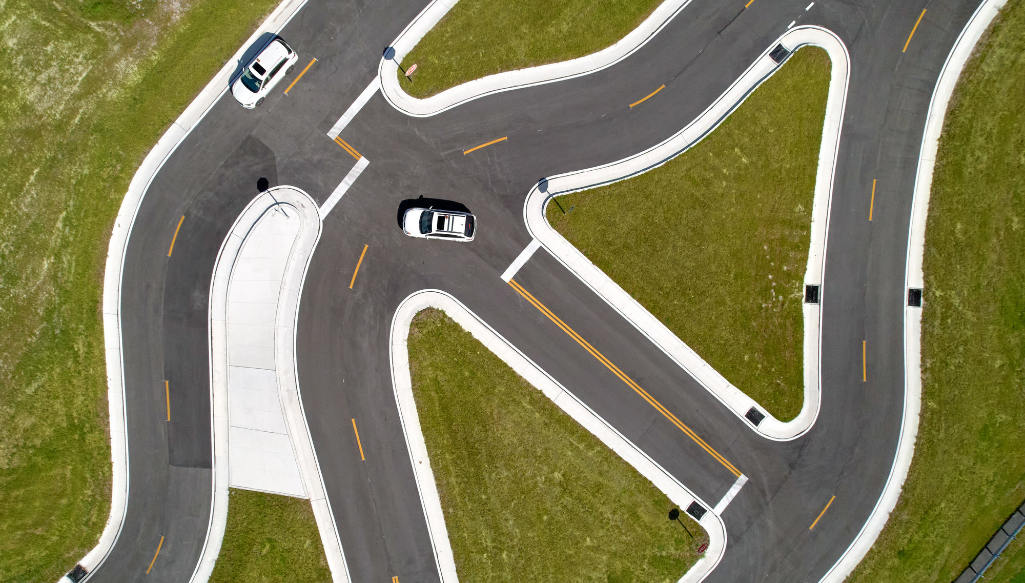 overhead shot of curved lanes with cars
